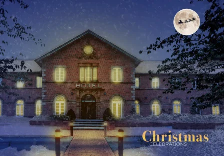 Cosy hotel with festive lighting, snowy trees, moonlit sky, and a Christmas celebration theme, ideal for winter getaways.
